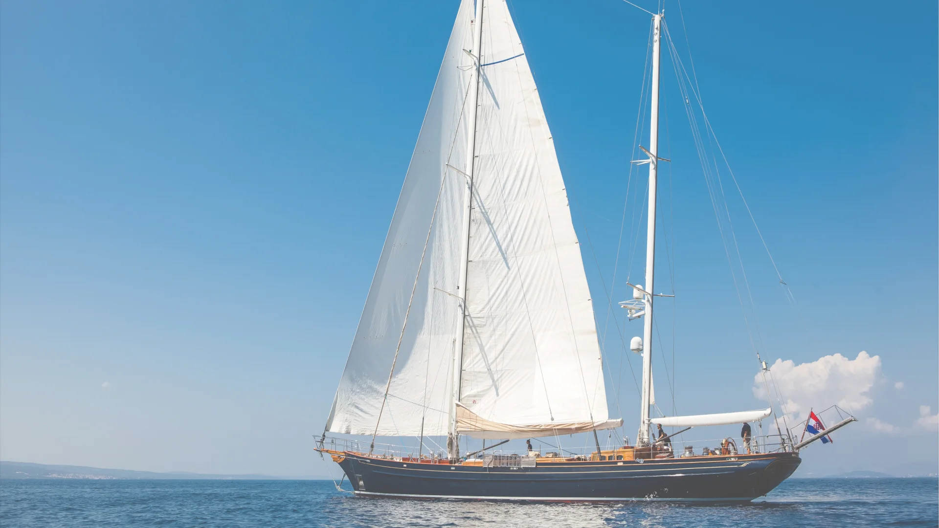 Andromeda yacht sailing at sea under a blue sky